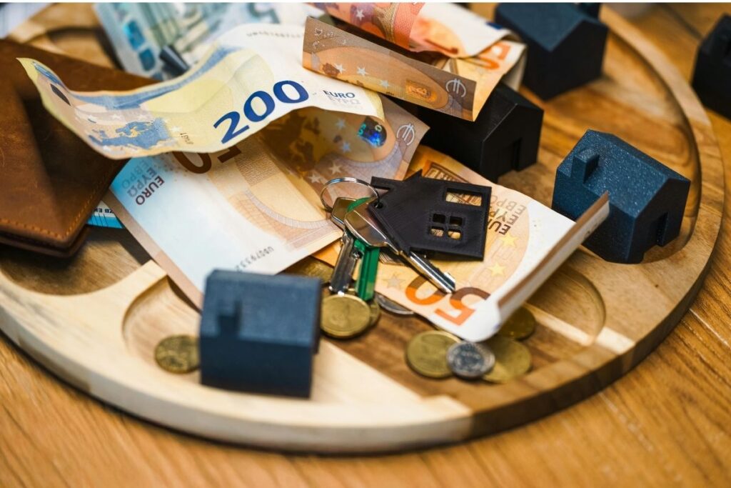 Drop zone with money, wallet, and house keys on a wooden tray.