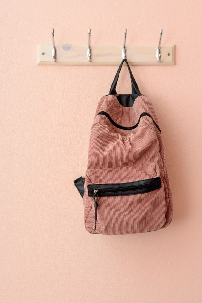 Single backpack hanging on a wall hook as part of a simple morning launch station setup